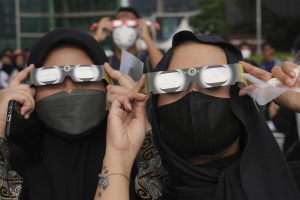 Индонезийские женщины используют специальные очки, чтобы увидеть затмение.  - Sputnik Узбекистан