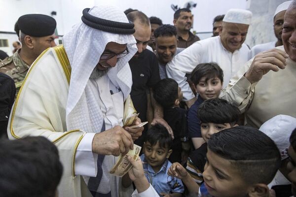Шейх Мохамед аль-Мулла, глава суннитского вакуфа Басры, раздает деньги детям, Ирак. - Sputnik Узбекистан