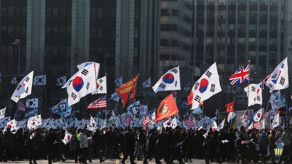 Участники митинга с флагами Южной Кореи, США, Великобритании на одной из улиц в Сеуле. - Sputnik Ўзбекистон
