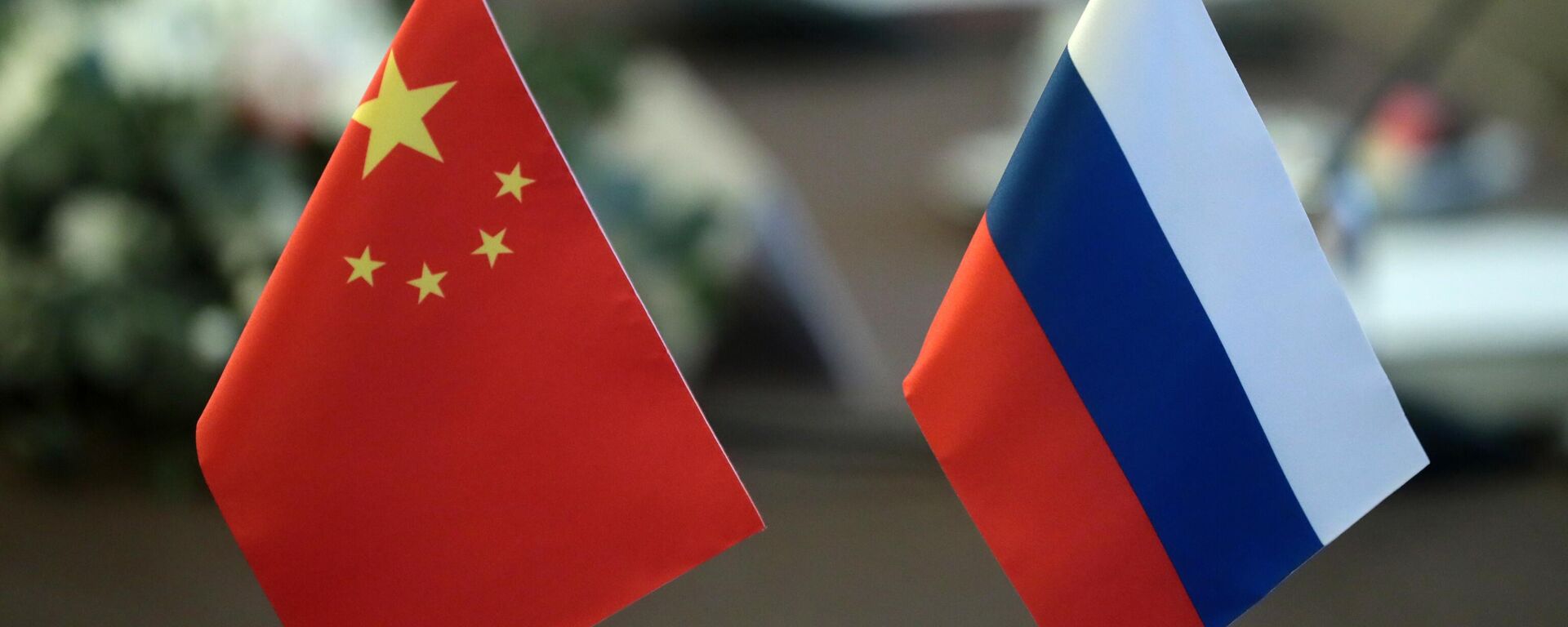 Флаги за столом переговоров секретаря Совета безопасности РФ Николая Патрушева и главы канцелярии комиссии по иностранным делам ЦК КПК, члена Политбюро ЦК Компартии Китая Вана И в Москве. - Sputnik Ўзбекистон, 1920, 20.09.2025