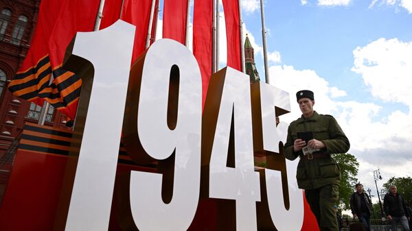 Солдат проходит мимо декораций на Красной площади ко Дню Победы, Россия - Sputnik Узбекистан