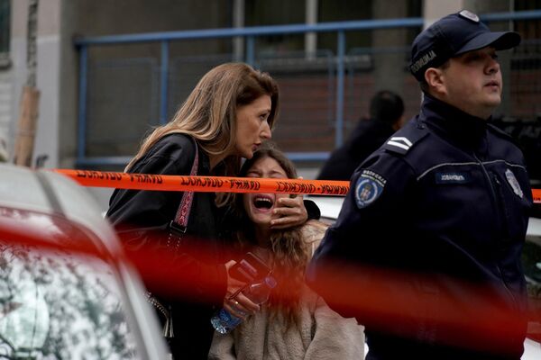Родитель забирает своего ребенка из школы Белграда после стрельбы.  - Sputnik Узбекистан