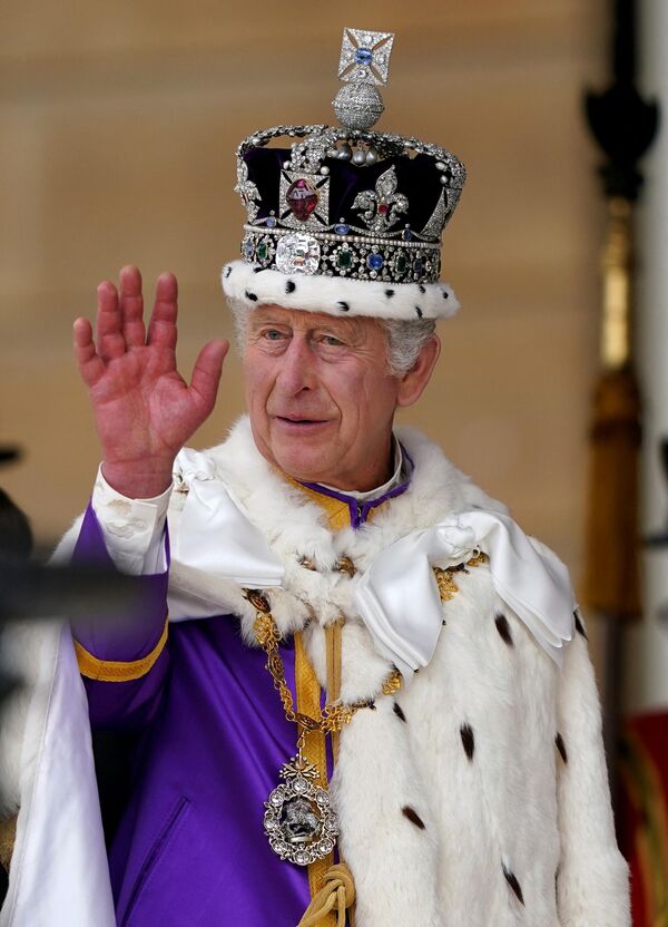 Король Карл III машет рукой, принимая салют от военных на Букингемской площади в Лондоне. - Sputnik Узбекистан