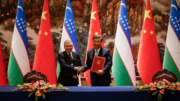 Председатель КНР Си Цзиньпин и президент Узбекистана Шавкат Мирзиеев (слева) пожимают друг другу руки во время церемонии подписания на полях саммита Китай-Центральная Азия в Сиане, провинция Шэньси, 18 мая 2023 года. - Sputnik Узбекистан