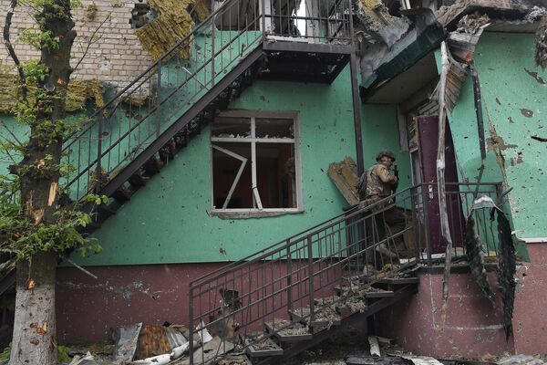 Боец ЧВК &quot;Вагнер&quot; заходит в разрушенный дом в Артёмовске. - Sputnik Узбекистан