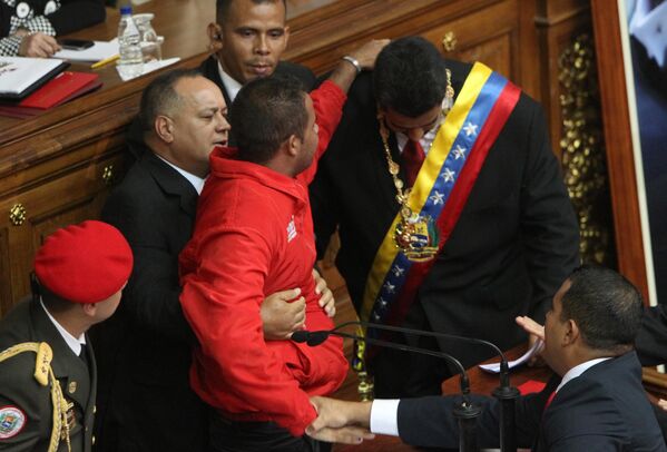 Охрана президента Венесуэлы Николаса Мадуро пытается оградить его от неизвестного, прорвавшегося на трибуну во время церемонии инаугурации.  - Sputnik Узбекистан