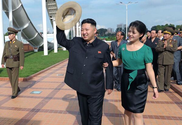 Северокорейский лидер Ким Чен Ын (в центре) в сопровождении своей жены Ли Соль Чжу (справа) - Sputnik Узбекистан
