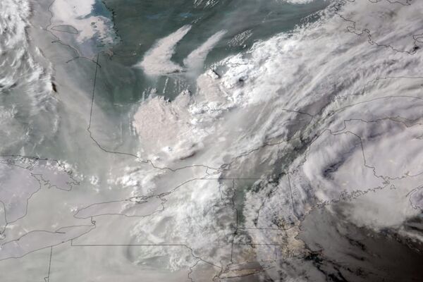 Спутниковый снимок GOES-16 GeoColor показывает, как дым от лесных пожаров в Квебеке, смещается на юг. - Sputnik Узбекистан