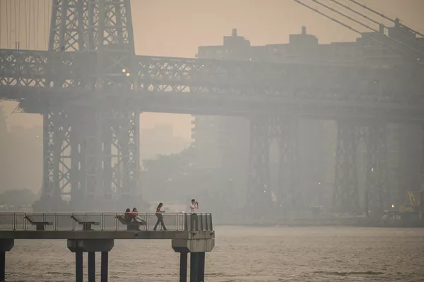 Люди стоят на пирсе на фоне окутанного дымом горизонта Нью-Йорка в Бруклине. - Sputnik Узбекистан