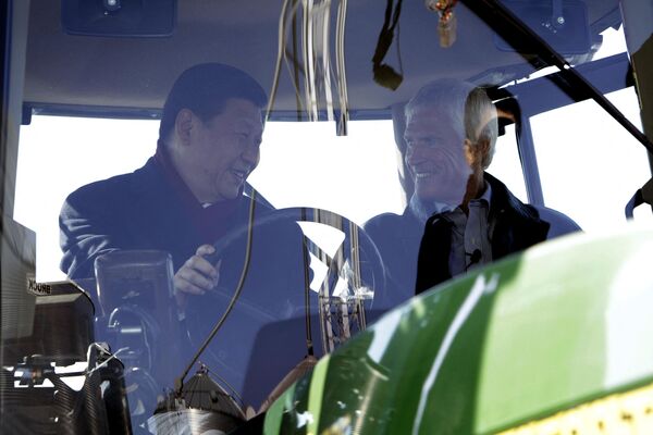 Вице-председатель Китая Си Цзиньпин и фермер Рик Кимберли за рулем трактора на ферме в Айове, США.  - Sputnik Узбекистан