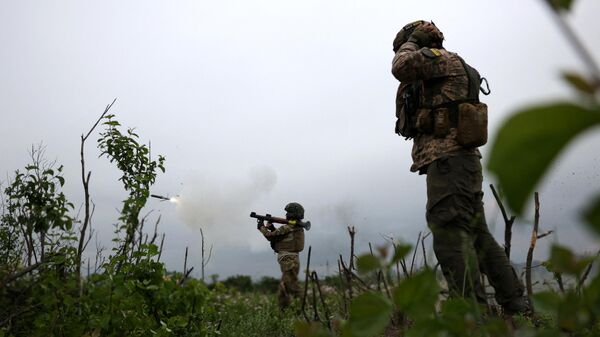 Украинские военнослужащие 28-й отдельной механизированной бригады стреляют из гранатомета на линии фронта близ города Бахмут Донецкой области, 17 июня 2023 года. - Sputnik Узбекистан