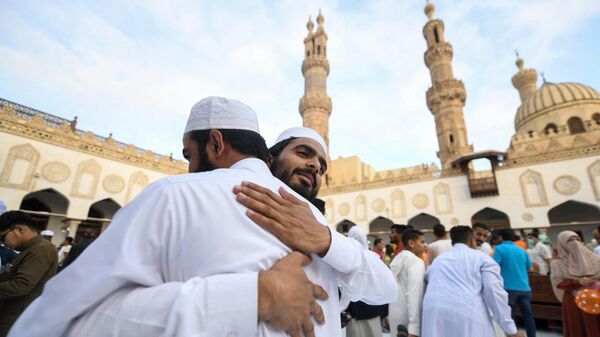 Верующие мусульмане приветствуют друг друга после утренней молитвы по случаю праздника Курбан-Байрам в исторической мечети Азхар в центре Каира, Египет - Sputnik Ўзбекистон