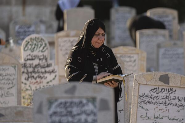 Женщина молится на кладбище в Багдаде, Ирак. - Sputnik Узбекистан