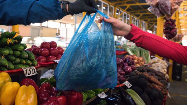 Продавец передает пакет с продуктами покупателю на Центральном рынке Адлерского района Сочи - Sputnik Узбекистан