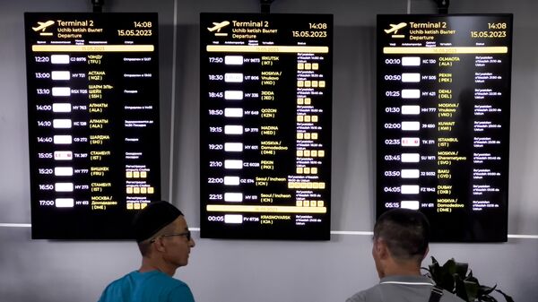 Пассажиры у электронных табло с информацией о вылете в международном аэропорте имени Ислама Каримова в Ташкенте. - Sputnik Узбекистан