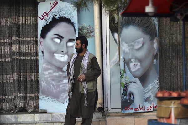 В первые дни правления нынешних властей Афганистана изображение женщин на витринах салонов красоты снимали или закрашивали, Кабул, сентябрь 2021 года. - Sputnik Узбекистан