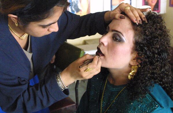 Мастер макияжа Шиба в салоне красоты в Кабуле наносит последние штрихи на лицо клиентки, собирающейся на свадьбу, 25 сентября 2002 года. - Sputnik Узбекистан