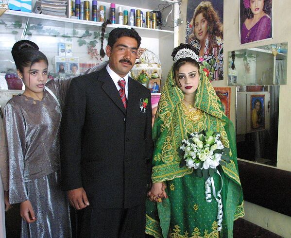 Невеста по имени Фрозан (справа) и ее жених перед свадьбой в салоне красоты Сохейла в Кабуле, 25 сентября 2002 года. - Sputnik Узбекистан