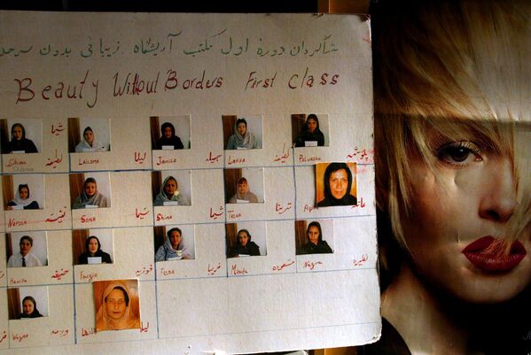 Фотографии выпускниц школы бьюти-мастеров рядом с постером в салоне красоты в Кабуле, октябрь 2004 года.  - Sputnik Узбекистан