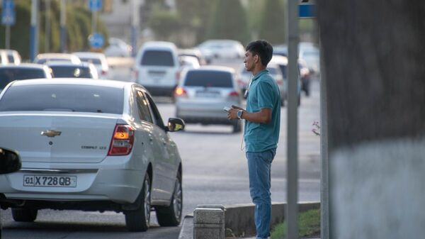 Парень стоит возле пешеходного перехода на одном из улиц Ташкента - Sputnik Узбекистан