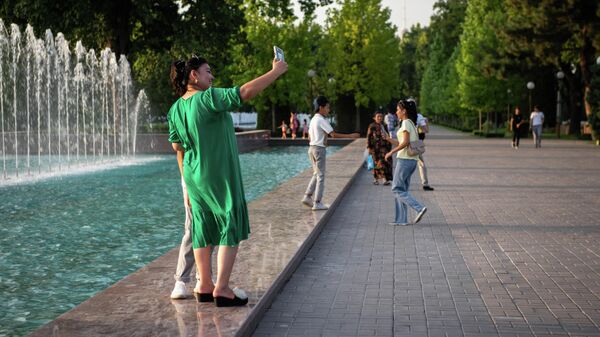 Люди фотографируются у фонтана на площади Мустакиллик  - Sputnik Узбекистан