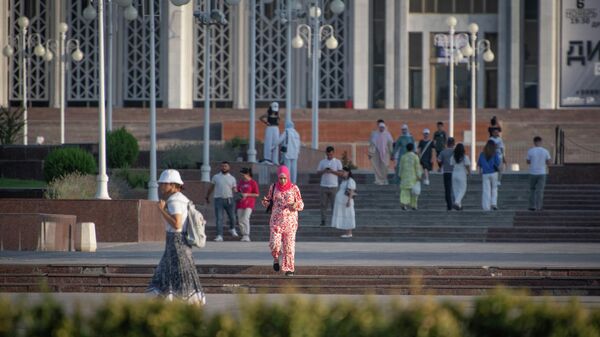 Девушка в платке идет по площади перед дворцом Дружбы народов - Sputnik Узбекистан