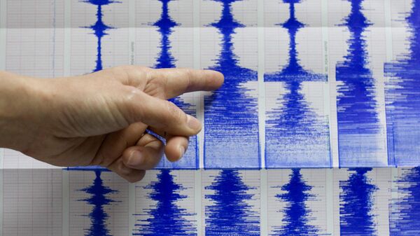 Сотрудник Центрального бюро погоды Тайваня Лу Пей-лин указывает на данные сейсмографа о землетрясении  - Sputnik Узбекистан