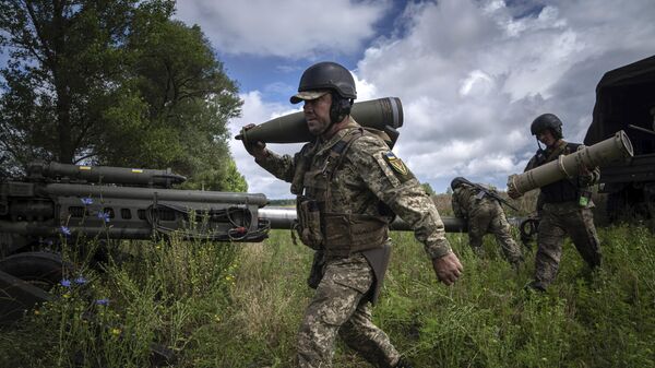 Украинский военный со снарядом 155 мм в Харьковской области. Архивное фото  - Sputnik Ўзбекистон