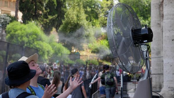 Туристы прохлаждаются возле вентилятора, стоя в очереди на вход в римский Колизей, Италия - Sputnik Узбекистан