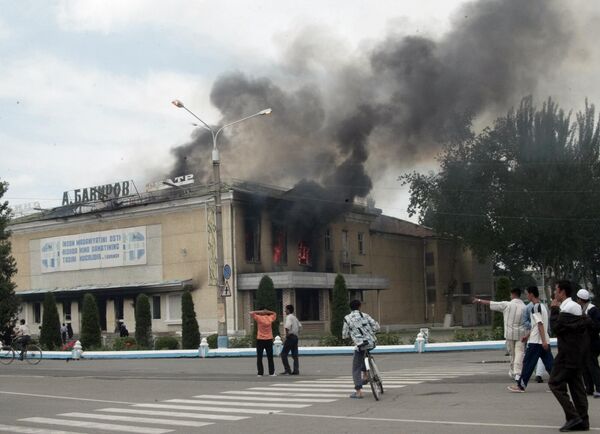 Люди выходят из горящего кинотеатра в центре Андижана в пятницу, 13 мая 2005 года.  - Sputnik Ўзбекистон