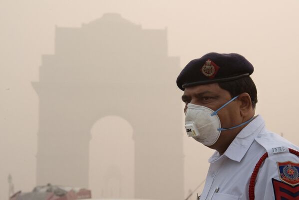 Особенно тяжело в условиях смога тем, кто по долгу службы вынужден подолгу находиться на улице. Индийский полицейский в в Нью-Дели вынужден работать в маске, чтобы уберечь здоровье от загрязненного воздуха.  - Sputnik Узбекистан