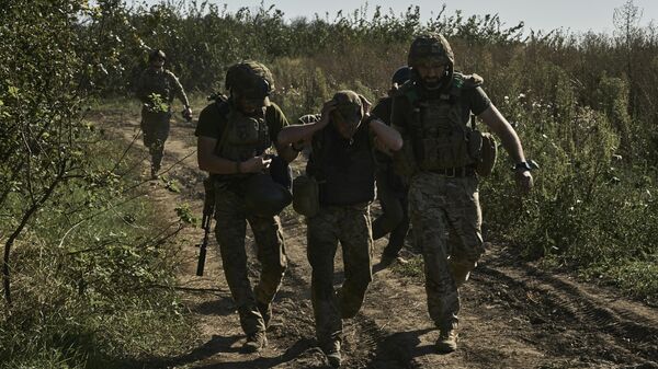 Ukraina askarlari Baxmut yaqinidagi frontdan yaralangan askarni evakuatsiya qilmoqda. - Sputnik O‘zbekiston