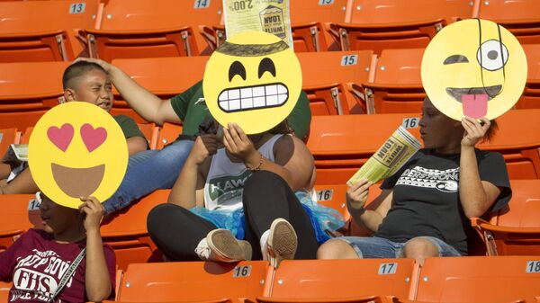 Фанаты с Гавайских островов держат маски смайликов перед началом футбольного матча, США - Sputnik Узбекистан