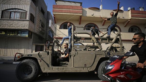 Палестинские бойцы едут на захваченной израильской военной машиной в секторе Газа 7 октября 2023 года. - Sputnik Узбекистан