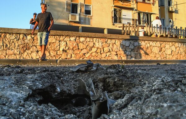 Воронка с фрагментами снаряда в жилом квартале Ашкелона, пострадавшем от обстрела группировкой ХАМАС.  - Sputnik Узбекистан