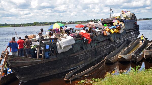 Пассажиры и торговцы садятся на баржу на реке Конго в Мбандаке, на севере Демократической Республики Конго. Архивное фото - Sputnik Узбекистан