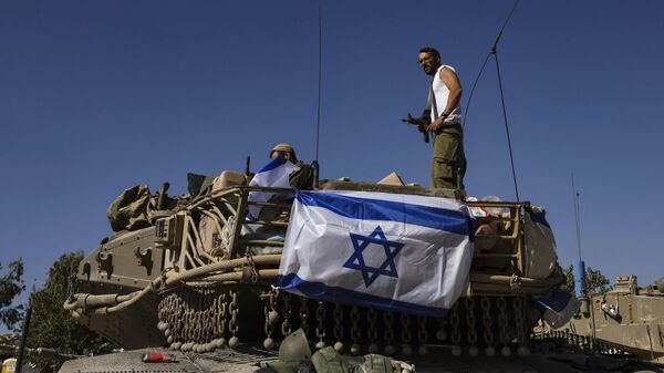 Израильский солдат стоит на крыше танка Меркава недалеко от границы с сектором Газа, 20 октября 2023 года. - Sputnik Узбекистан