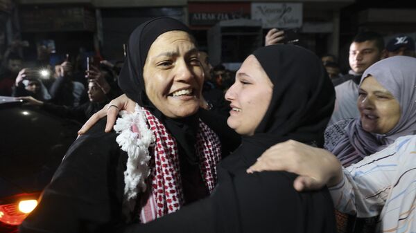 Равда Абу Аджамие обнимает родственницу после освобождения из израильской тюрьмы в рамках соглашения о перемирии между Израилем и ХАМАС - Sputnik Узбекистан