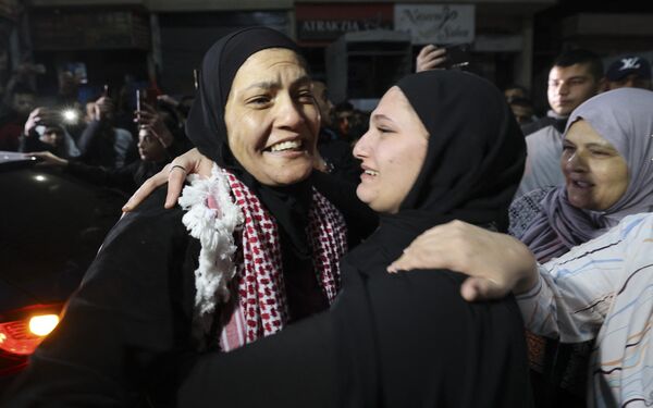 Одна из освобожденных палестинских заключенных обнимает родственников после долгой разлуки. - Sputnik Узбекистан