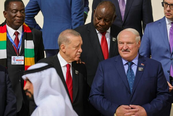 Belarus prezidenti Aleksandr Lukashenko turkiyalik hamkasbi Rejep Tayyip Erdog‘an bilan. Ikki davlat rahbarlari jamoaviy suratga tushishni kutishmoqda - Sputnik O‘zbekiston