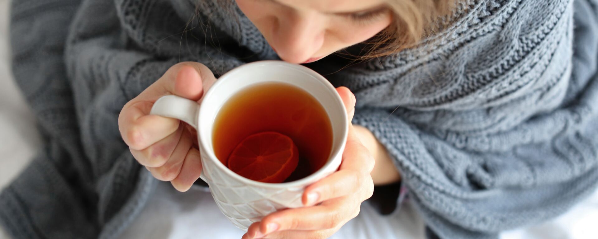 Больная девушка с чашкой горячего чая в постели  - Sputnik Узбекистан, 1920, 21.12.2023