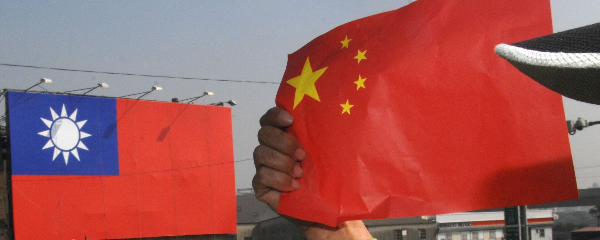 Протестующий держит национальный флаг Китая - Sputnik Ўзбекистон, 1920, 15.01.2024