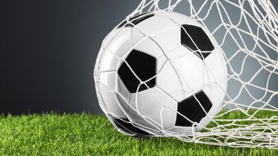 Футбольный мяч в воротах.