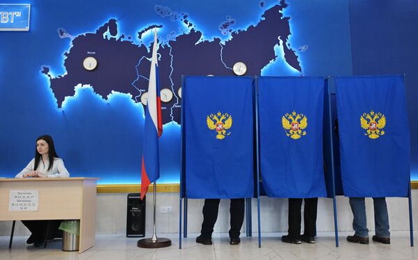 Люди голосуют на выборах президента России на одном из избирательных участков в Новосибирске - Sputnik Узбекистан