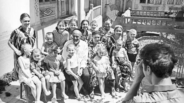 Кузнец Шаахмед Шамахмудов и его жена Бахрихон с усыновленными во время Великой Отечественной войны 1941-1945 годов детьми и внуками. - Sputnik Узбекистан