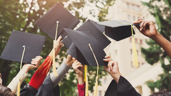 Группа выпускников подбрасывает выпускные шапочки в воздух  - Sputnik Узбекистан