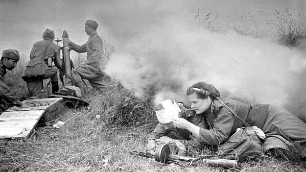 45 мм калибрли қурол батареясининг тиббий йўриқчиси Анна Андреевна Соколова (1922-07.08.1943) Орел-Курск йўналишидаги жангда яраланган аскарни боғламоқда. 45 мм калибрли қурол батареясининг тиббий йўриқчиси Анна Андреевна Соколова (1922-07.08.1943) Орел-Курск йўналишидаги жангда яраланган аскарни боғламоқда. - Sputnik Ўзбекистон