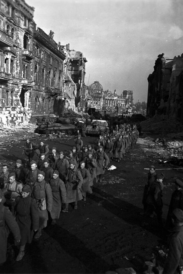 1945 йил 16 апрелдан 8 майгача Берлин стратегик ҳужум операцияси. Қизил Армия аскарлари колоннаси Берлинда Рейхстаг яқинида юришда. Орқа фонда Т-34-85 танклари ва СУ-76М ўзиюрар қуроллари. 1945 йил 16 апрелдан 8 майгача Берлин стратегик ҳужум операцияси. Қизил Армия аскарлари колоннаси Берлинда Рейхстаг яқинида юришда. Орқа фонда Т-34-85 танклари ва СУ-76М ўзиюрар қуроллари. - Sputnik Ўзбекистон