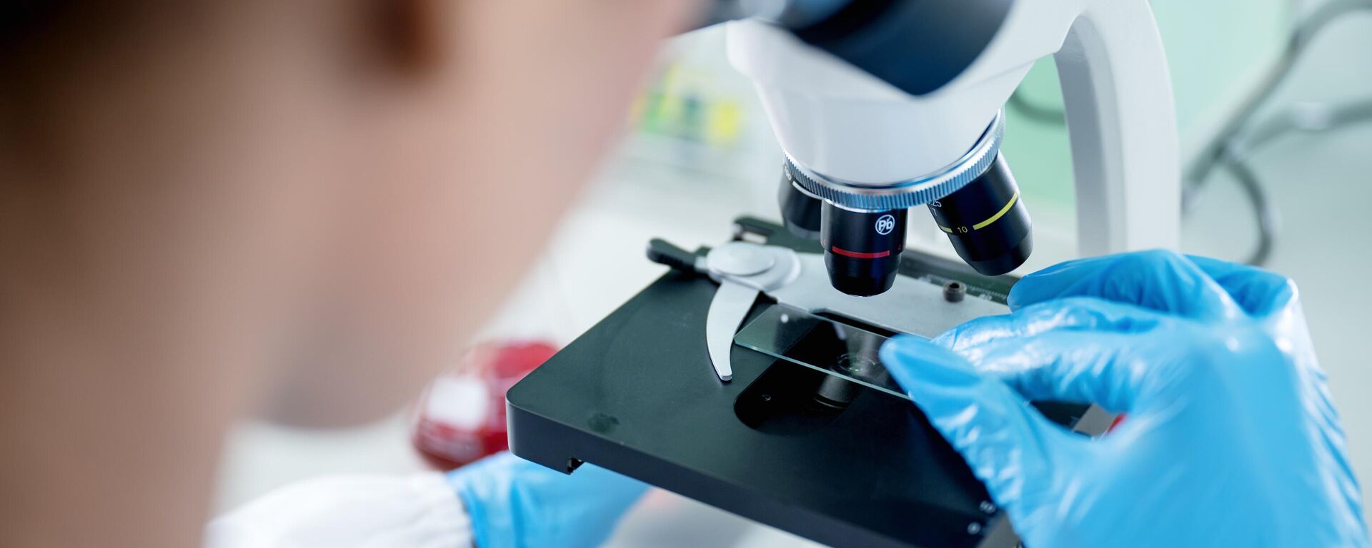 Женщина-ученый работает в современной лаборатории и использует микроскоп для анализа научного образца - Sputnik Узбекистан, 1920, 03.09.2025