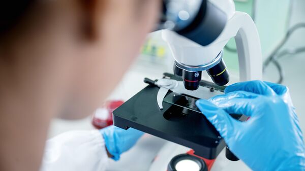 Женщина-ученый работает в современной лаборатории и использует микроскоп для анализа научного образца - Sputnik Узбекистан